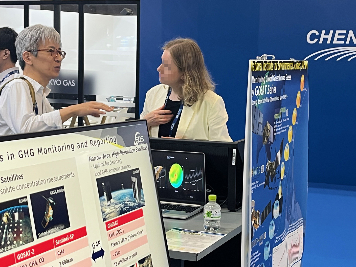 GOSATに関心のある来場者と歓談する梅澤主任研究員（写真左）